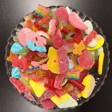 Assorted colorful gummy candies on a dark surface