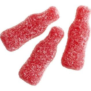 Three bright red gummy shaped as bottles covered in sour sugar, on a white background