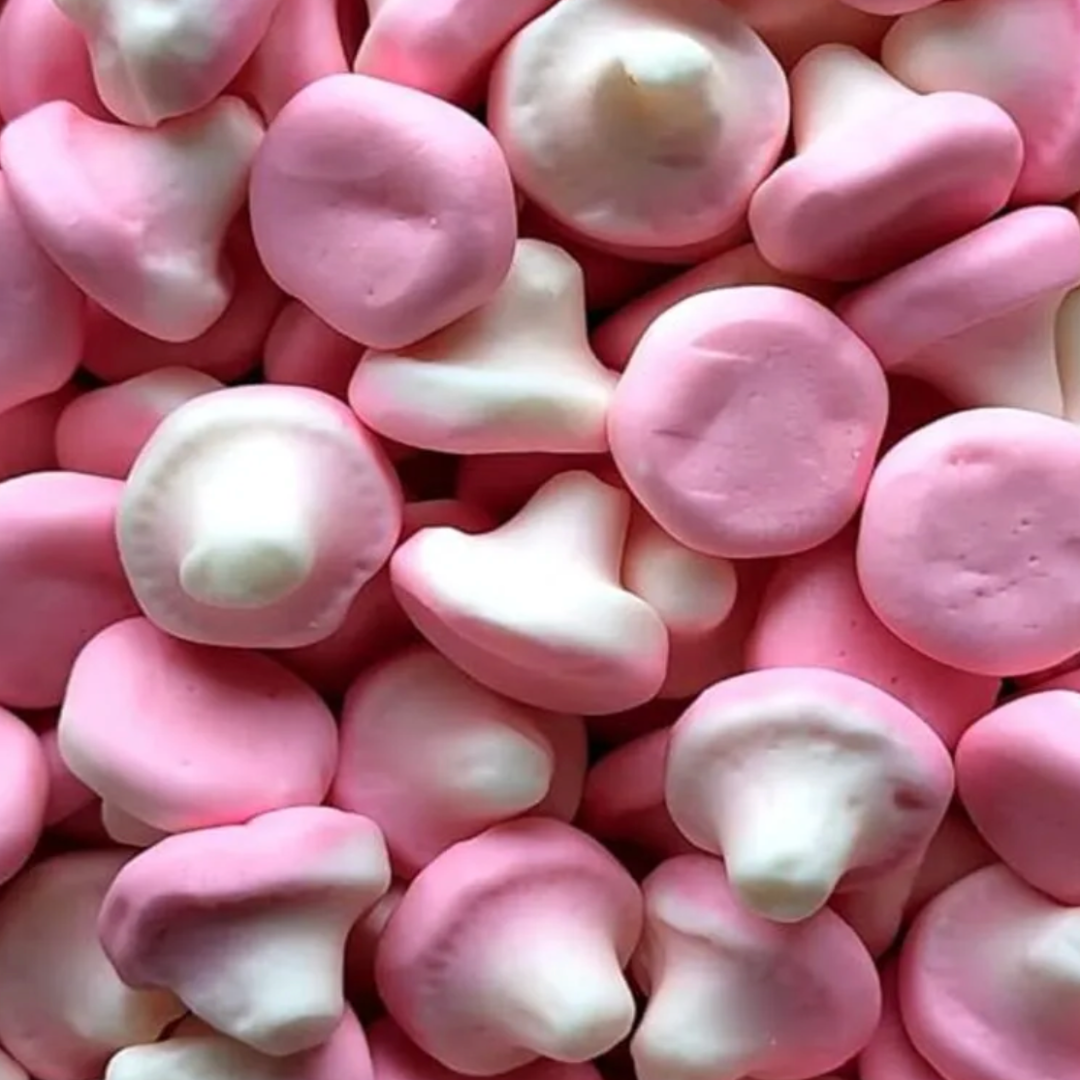 Close-up of pink and white candy pieces shaped as small cute mushrooms. Marshmallow soft strawberry vanilla taste.