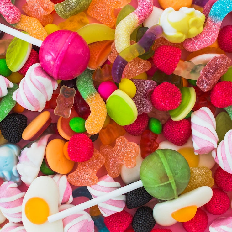 Assorted colorful candies including gummy bears, lollipops, and jelly beans.
