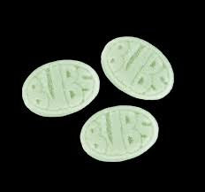 Three light green oval-shaped candies marked BUBS on a black background