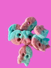 Colorful skull-shaped candies on a pink background