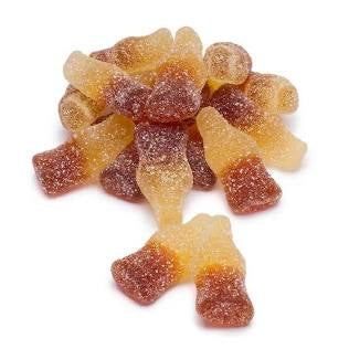 Pile of candies shaped as cute Coca Cola old fashion bottles. white background