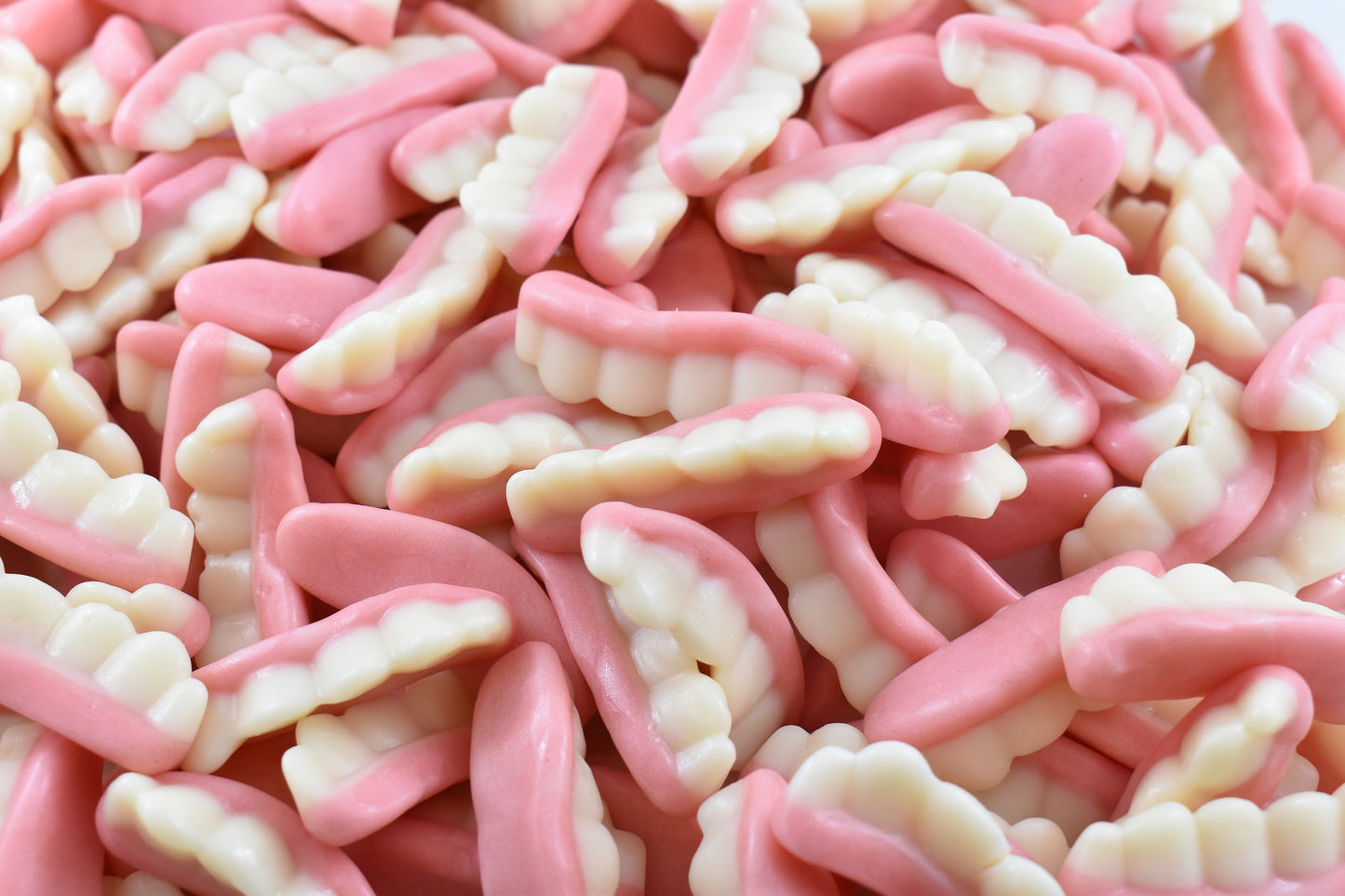 Close-up of pink and white candy piece that are shaped like grandmas teeth. A funny treat specially for halloween. pink and white