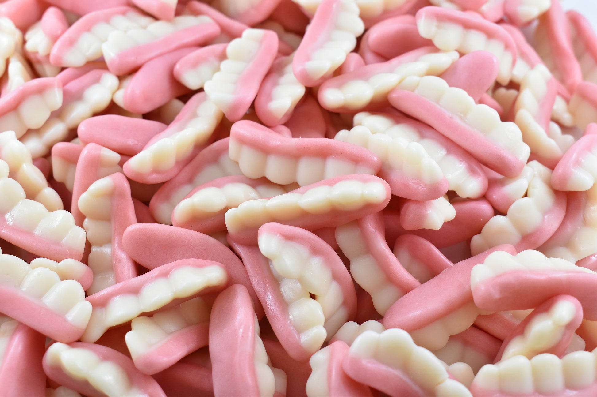 Close-up of pink and white candy piece that are shaped like grandmas teeth. A funny treat specially for halloween. pink and white