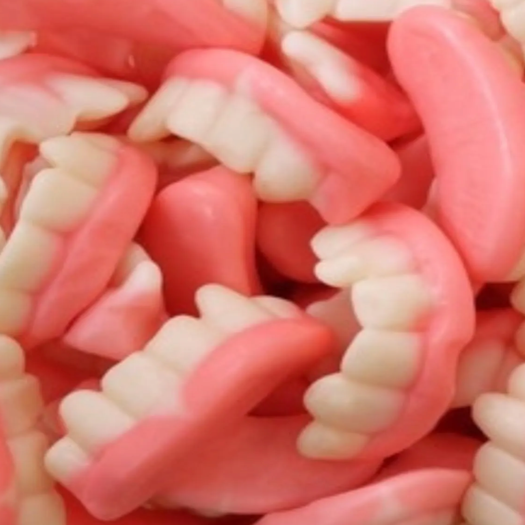 Close-up of pink and fake teeth. They are marshmallow candies shaped and looks like grandmas false teeth, 