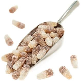 Metal scoop filled with sugared cute candy shaped as old fashion Coca Cola bottles on a white background