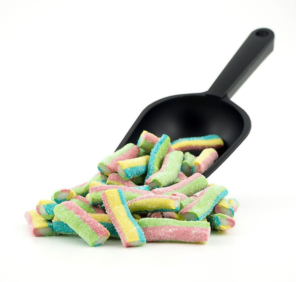 Black scoop with colorful rainbow gummy candy on a white background. Soft and chewy 