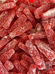 Close-up of red jelly candies with a sugary texture. Shaped as old fashion soda bottles. Soft and chewy texture.