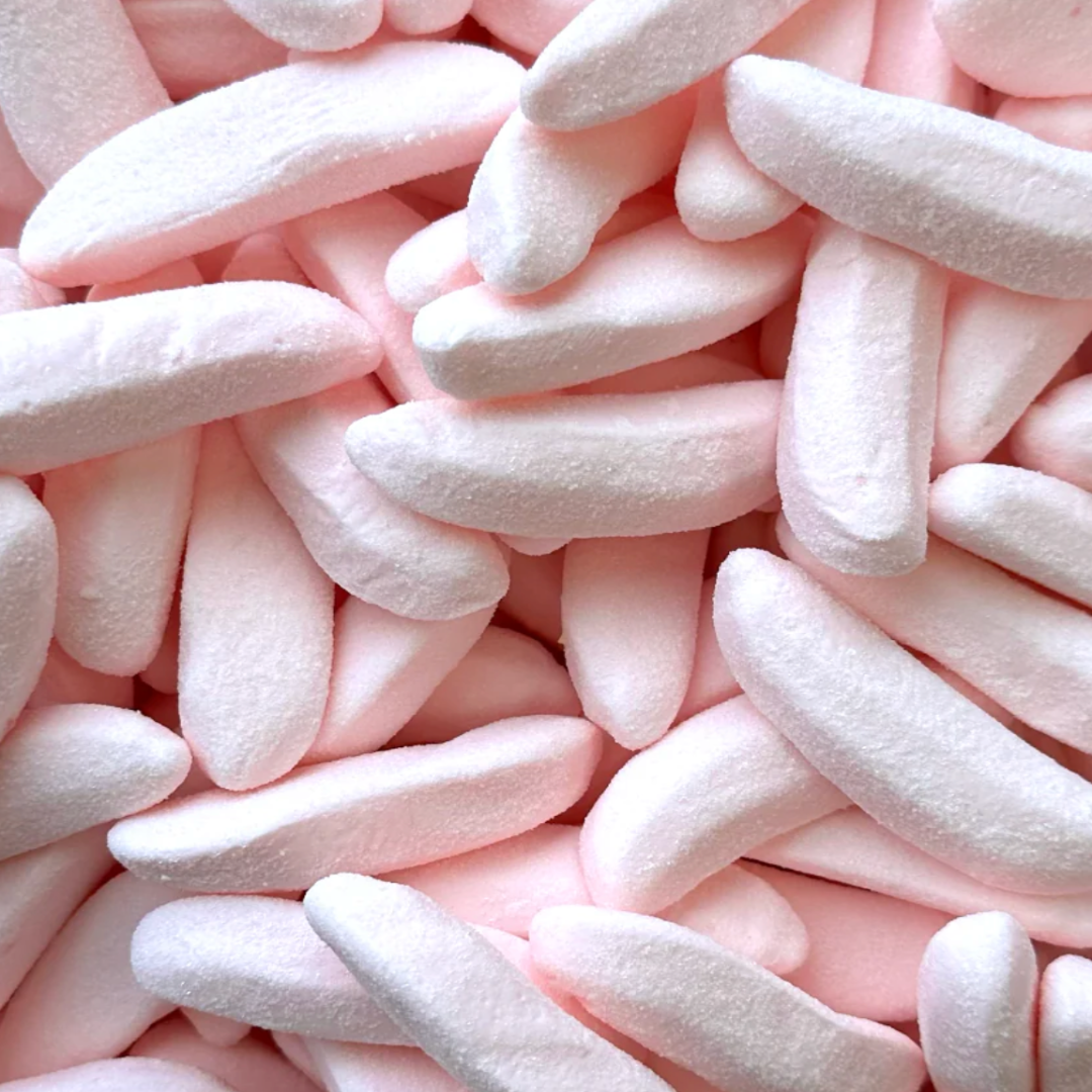 Close-up of pink and white  marshmallow candy shaped as mini bananas covered in sour sugar. Soft and bendable. 