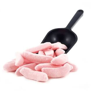 Black scoop with pink candy on a white background. Candy shaped as mini bananas.