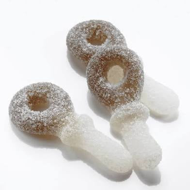 three chewy pacifiers candy covered in sour sugar. White background.