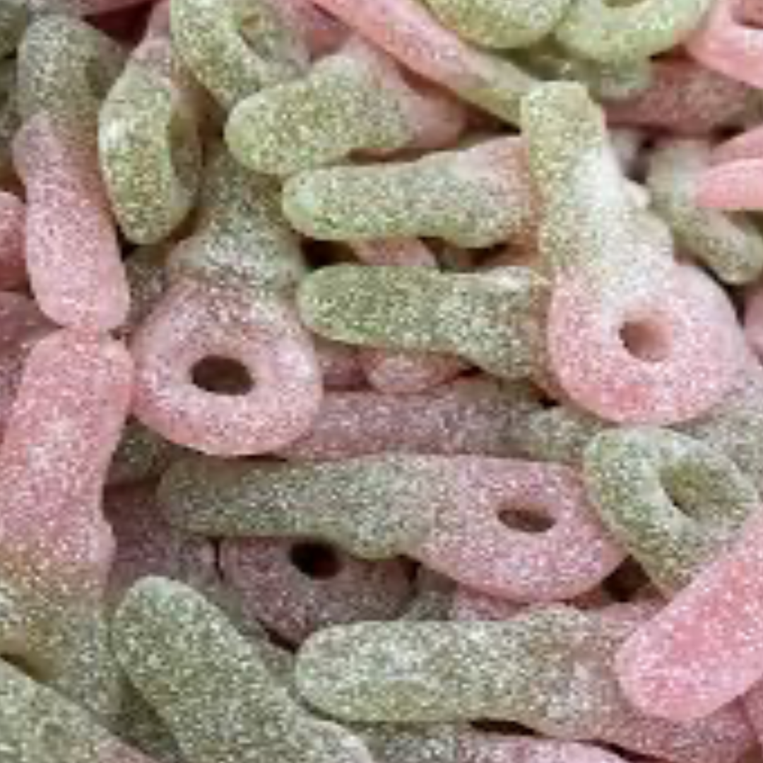 Close-up of colorful gummy candy shaped as pacifiers. Green and red color. Coverd in sour sugar. Soft and chewy.