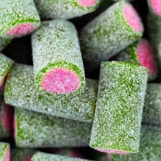 Close-up of green and pink candy stubs with pink center. Coated in sour sugar with a blurred background