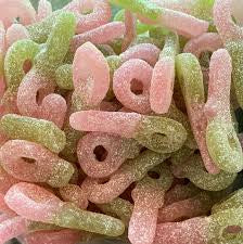 Close-up of colorful gummy candy shaped as pacifiers. Green and red color. Coverd in sour sugar.