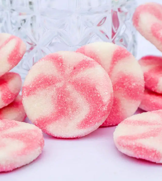 Pink and white swirled candies on a white background